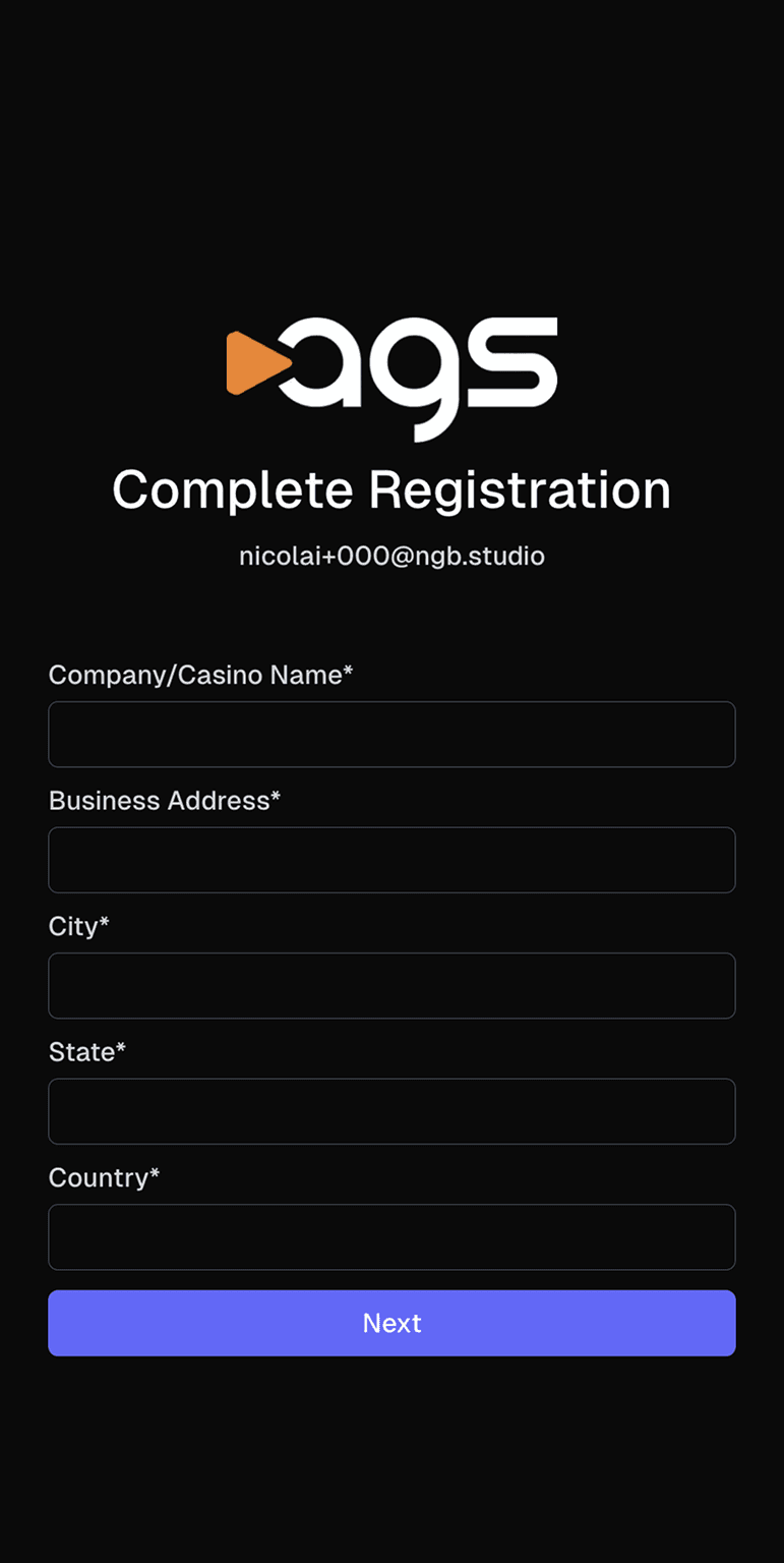 A registration screen with the ags logo (featuring an orange play button triangle next to white letters) on a black background. The page displays "Complete Registration" as a heading, with an email address "nicolai+000@ngb.studio" shown below it. The form contains five required fields marked with asterisks: Company/Casino Name, Business Address, City, State, and Country. All fields are empty text inputs. A purple button labeled "Next" appears at the bottom of the screen.